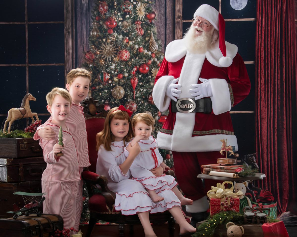 Santa standing with four children before a glowing Christmas tree at the Blackwater studio in the Ohio Valley