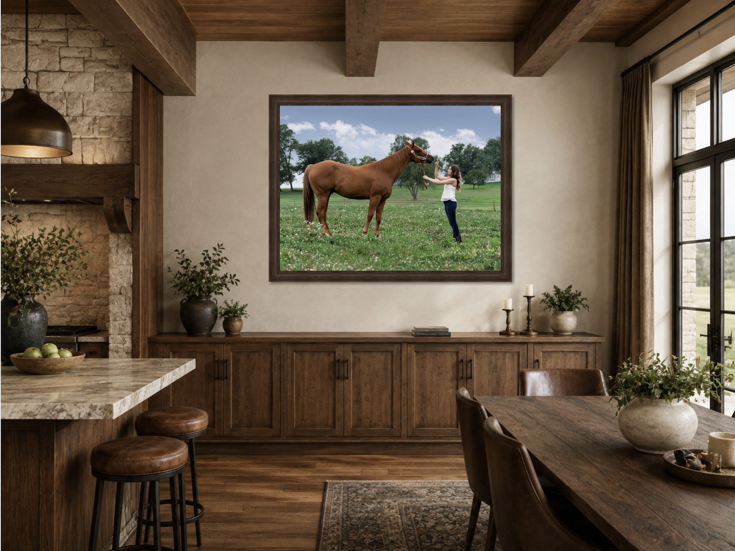 A large Blackwater fine art equine portrait of a young woman and her horse, framed above a wood sideboard in a rustic kitchen and dining room